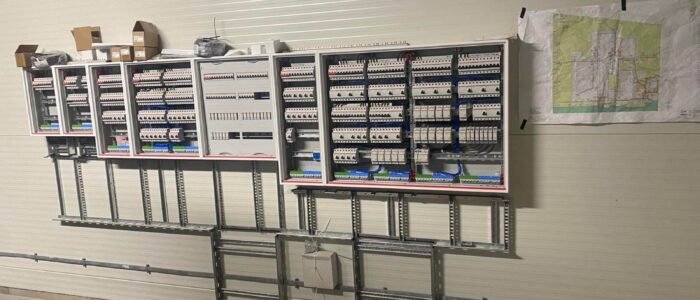 ELECTRICAL PANEL INSTALLATION (1) Commercial electrical panel upgrade on-site, featuring multiple breaker panels and cable management for efficient industrial electrical services.